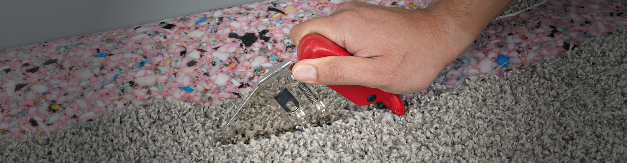 Close-up of installer using ROBERTS Loop Pile Cutter to cut carpet during installation