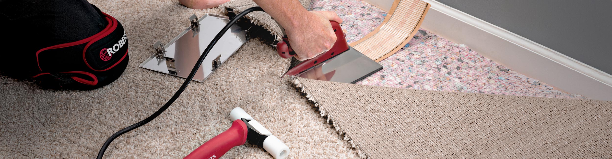 Installer using ROBERTS 6 in. Heat Bond Seaming Iron to heat up seam tape during carpet installation