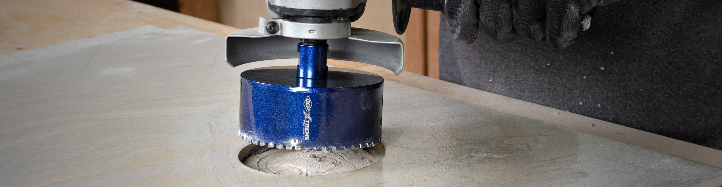 Close-up of QEP's 2-1/2" Xtreme Diamond Hole Saw being used to drill a hole in ceramic tile