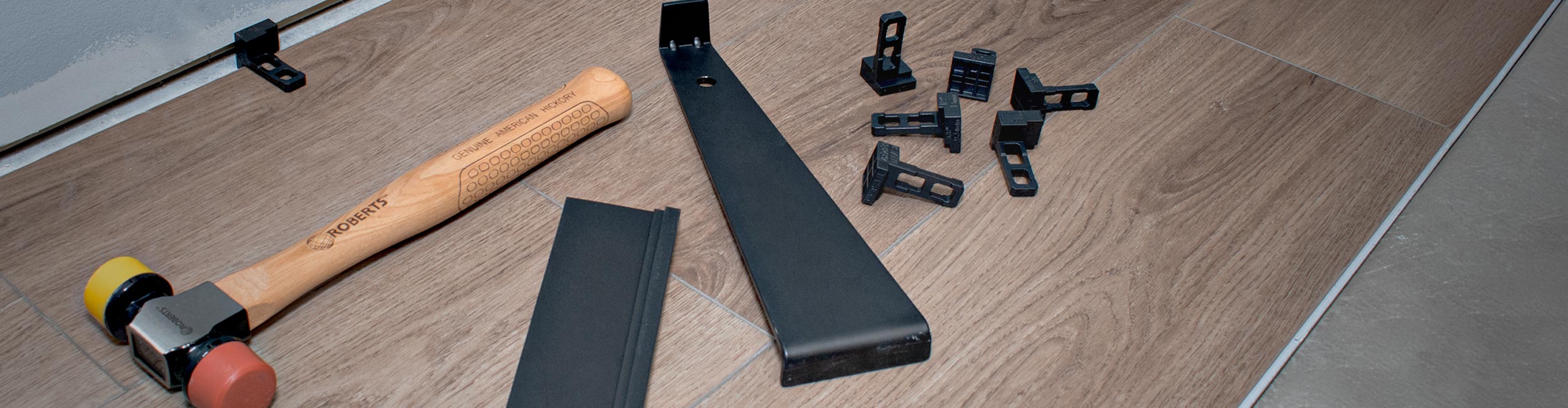 Close-up of ROBERTS Pro Flooring Installation Kit laying out on tan vinyl flooring