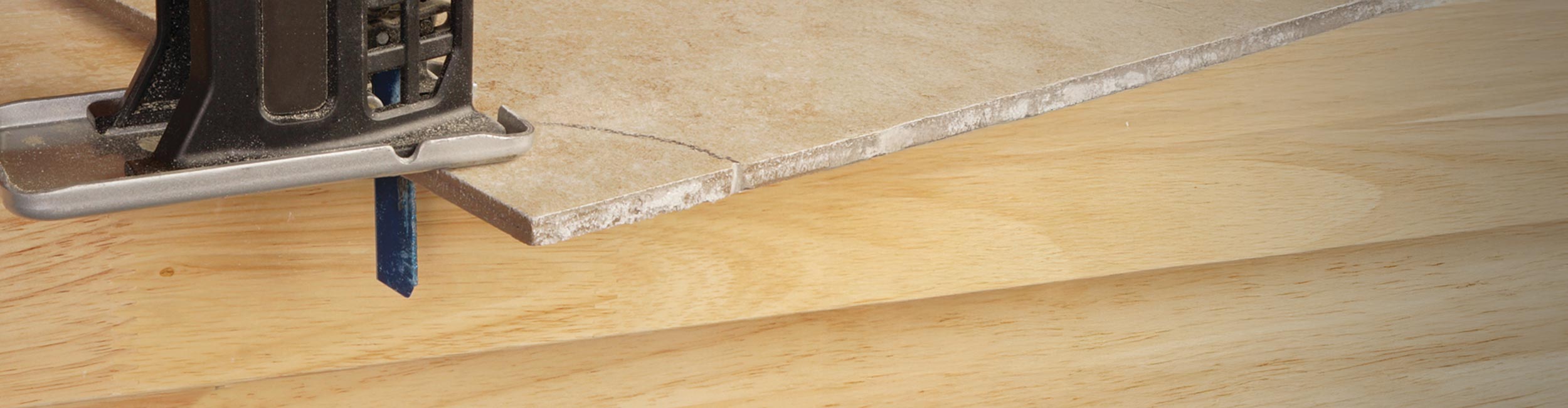 Close-up of a jigsaw with QEP's 3 in. Diamond Jigsaw Blade cutting a curve out of ceramic tile