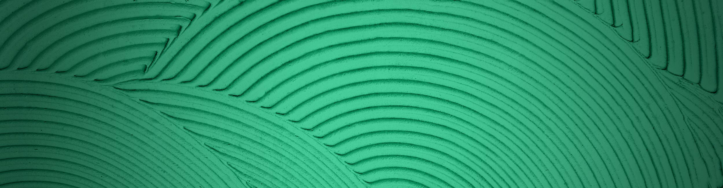 Close-up of textured trowel ridges with circular patterns on a green background