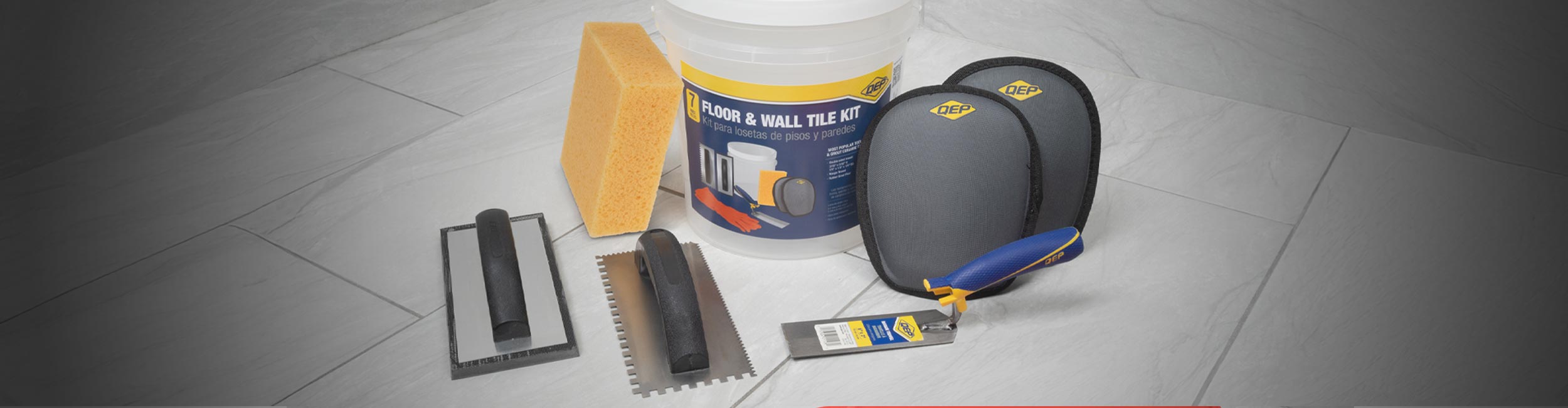 QEP's Floor & Wall Tile Installation Kit spread out on a gray tile flooring